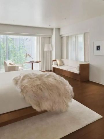 Lichtdurchflutetes Hotelzimmer mit luxuriösem Bett und Sitzgelegenheiten