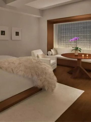 Hotelzimmer mit Sitzgelegenheit am Fenster und minimalistischer Dekoration