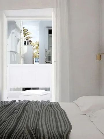 Helles Schlafzimmer mit Blick auf Balkon und Palmen