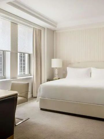 Helles und elegantes Hotelzimmer mit einem großen Bett und modernem Dekor