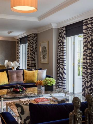 Moderne Suite mit eleganten Möbeln und stilvollen Vorhängen
