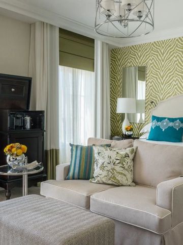 Elegantes Hotelzimmer mit stilvoller Einrichtung in neutralen Tönen und blauen Kissen.