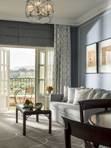 Helles Wohnzimmer mit Zugang zum Balkon und Ausblick auf die Landschaft.