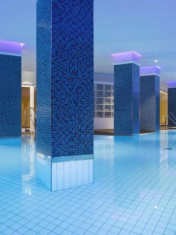 Moderner Indoor-Pool mit blauen Fliesen und violetter Beleuchtung