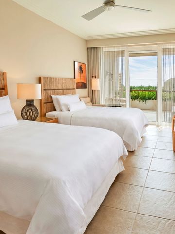 Modernes Doppelzimmer mit zwei Betten, stilvolle Beleuchtung und Ausblick auf die Natur.