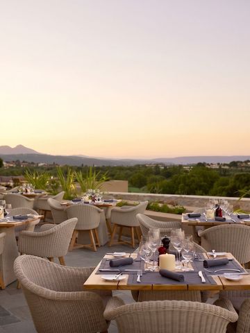 Restaurantterrasse bei Sonnenuntergang mit herrlichem Blick auf die Landschaft, gedeckte Tische.