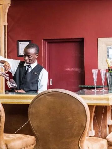 Barkeeper schenkt Wein ein in einer stilvollen Hotelbar