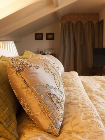 Komfortables Bett mit dekorativen Kissen in einem stilvollen Gästezimmer.