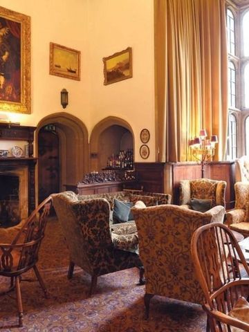 Elegante Lounge mit antiken Möbeln und großem Kamin im Thornbury Castle.