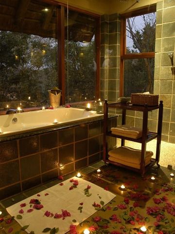 Luxuriöses Badezimmer mit Kerzen und Rosenblättern in der Thornybush Game Lodge
