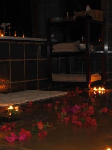 Stimmungsvolle Beleuchtung in der Badewanne mit Kerzen und Rosenblättern
