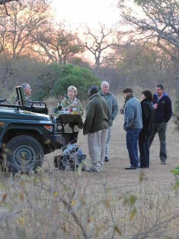 Gruppe von Menschen bei einer Safari im Freien mit einem Safari-Fahrzeug