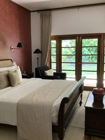 Luxuriöses Schlafzimmer mit großem Bett und Gartenausblick