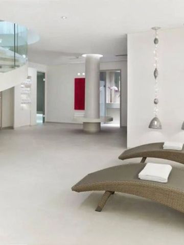Moderner Spabereich mit Liegen und geschwungener Treppe