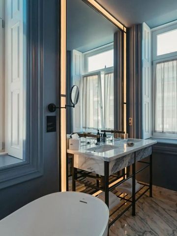Luxuriöses Badezimmer mit Marmor-Interieur und großen Fenstern