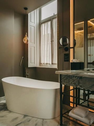 Luxuriöses Badezimmer mit freistehender Badewanne und Marmorakzenten