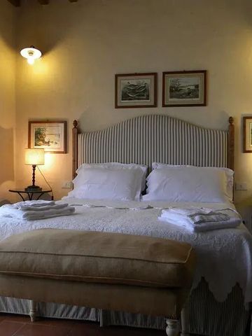 Gemütliches Schlafzimmer mit Kunstwerken an den Wänden und weicher Beleuchtung