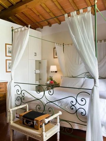 Elegantes Schlafzimmer mit Himmelbett und weißen Vorhängen im Hotel Torre a Cona