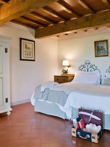 Gemütliches Schlafzimmer mit Holzbalkendecke und Doppelbett im Landhausstil