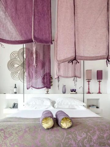 Helles Zimmer mit lila Details und eleganter Bettwäsche
