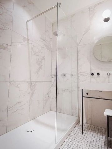 Minimalistisches Badezimmer mit Marmorfliesen und Dusche