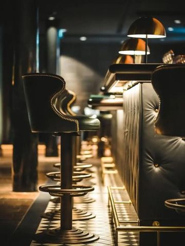 Stilvolle Bar mit gepolsterten Hockern und edlem Ambiente
