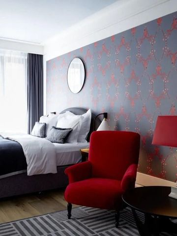 Gemütliches Schlafzimmer mit roten Akzenten und moderner Tapete