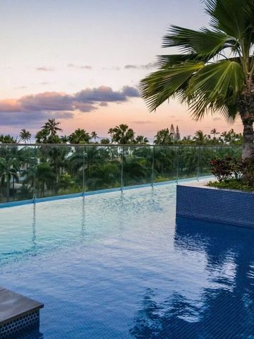Infinity-Pool mit Blick auf Palmen und Sonnenuntergang am Himmel