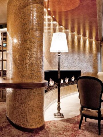 Luxuriöse Lounge mit gemütlichem Kamin im Tschuggen Grand Hotel