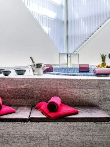 Entspannungsbereich mit Whirlpool, moderne Architektur und rote Handtücher