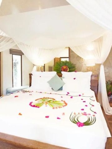 Himmelbett mit eleganter Dekoration und romantischen Blumenarrangements