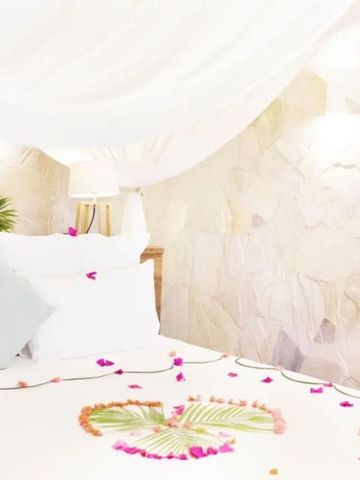 Nahaufnahme eines Himmelbetts mit floraler Dekoration und weichen Kissen
