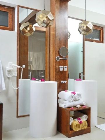 Modernes Badezimmer mit Doppelwaschbecken und eleganten, goldenen Lampen