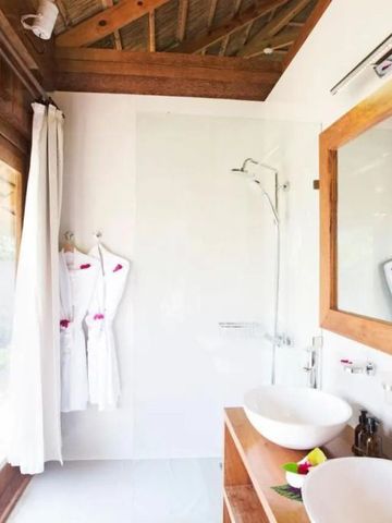 Badezimmer mit freistehender Dusche und Holzakzenten, helle und elegante Gestaltung