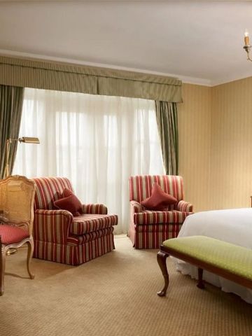 Elegantes Hotelzimmer mit Streifenmotiven und klassischem Dekor.