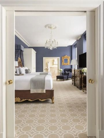 Luxuriöses Schlafzimmer mit Kronleuchter und blauen Wänden