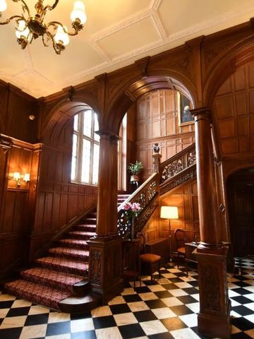 Prächtige Hotellobby mit beeindruckendem Holzinterieur und kunstvoller Treppe