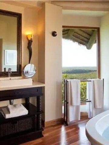 Modernes Badezimmer mit freistehender Badewanne und Blick auf die Natur.