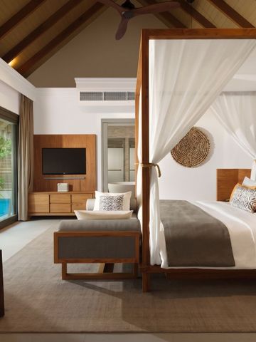 Geräumiges Schlafzimmer mit Himmelbett und privatem Poolblick