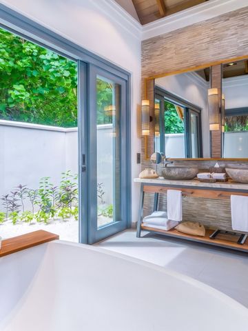 Modernes Badezimmer mit eleganter Badewanne und Gartenblick im Vakkaru Maldives.
