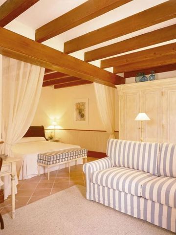 Gemütliches Schlafzimmer mit Holzbalken und gestreiftem Sofa