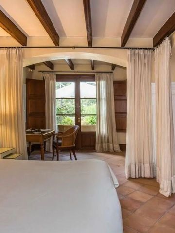 Elegantes Zimmer mit Holzbalkendecke und Gartenblick