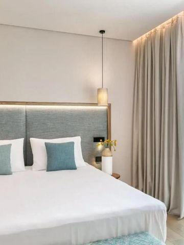 Geräumiges Hotelzimmer mit großem Bett und Vorhängen