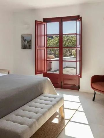 Helles Schlafzimmer mit Doppelbett Holzmöbeln und Blick auf die Umgebung