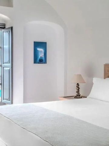 Schlafzimmer mit Blick auf den Pool durch geöffnete Türen und dezenter Dekoration