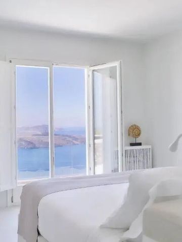Minimalistisch eingerichtetes Zimmer mit Meerblick durch große Fenster