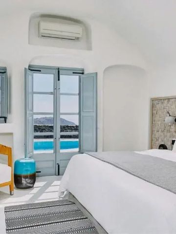 Zimmer mit Himmelbett und geöffneten Fensterläden blickt auf Pool und Meer
