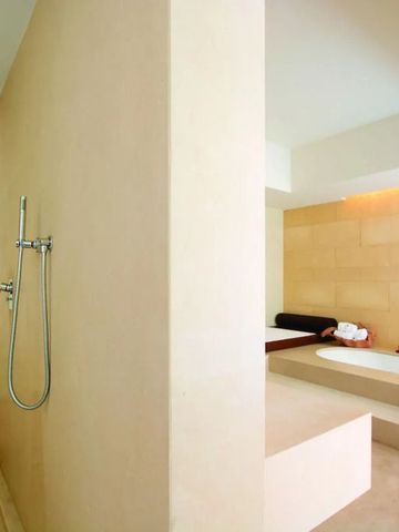Modernes Badezimmer mit Dusche und Badewanne im Verdura Resort.