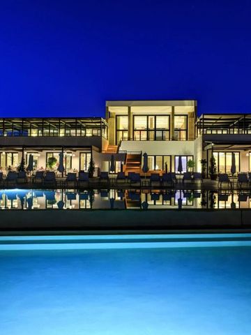 Wunderschön beleuchteter Hotelkomplex bei Nacht mit Pool im Vordergrund