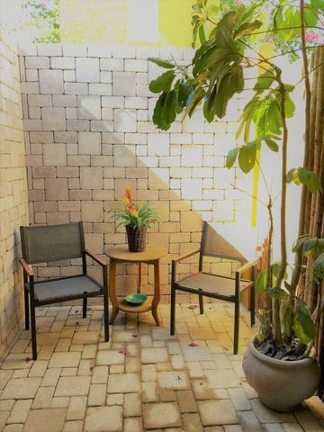 Ruhige Terrasse mit Pflanzen und Sitzgelegenheiten aus Stein und Holz
